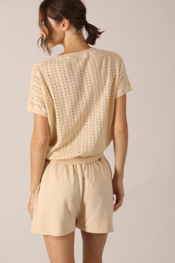 This elegant beige set is perfect for women who want a sophisticated and refined look. The beige knitted top with short open knitted sleeves is made of soft cotton, ensuring comfort and freshness throughout the day.